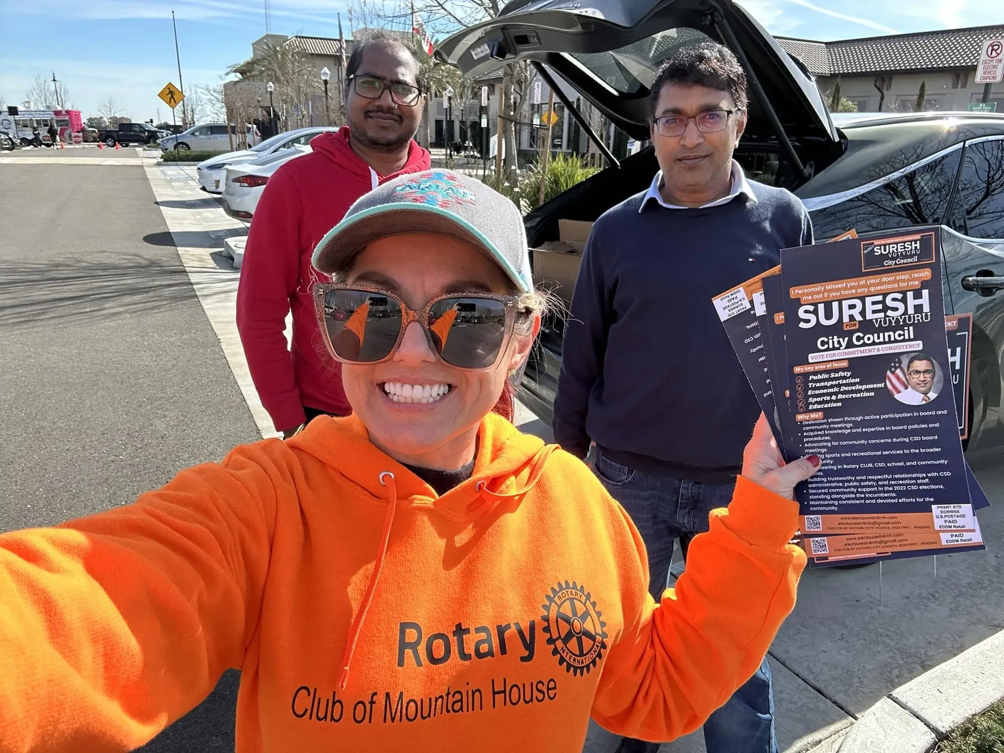 Suresh volunteering at a Rotary event with campaign flyer