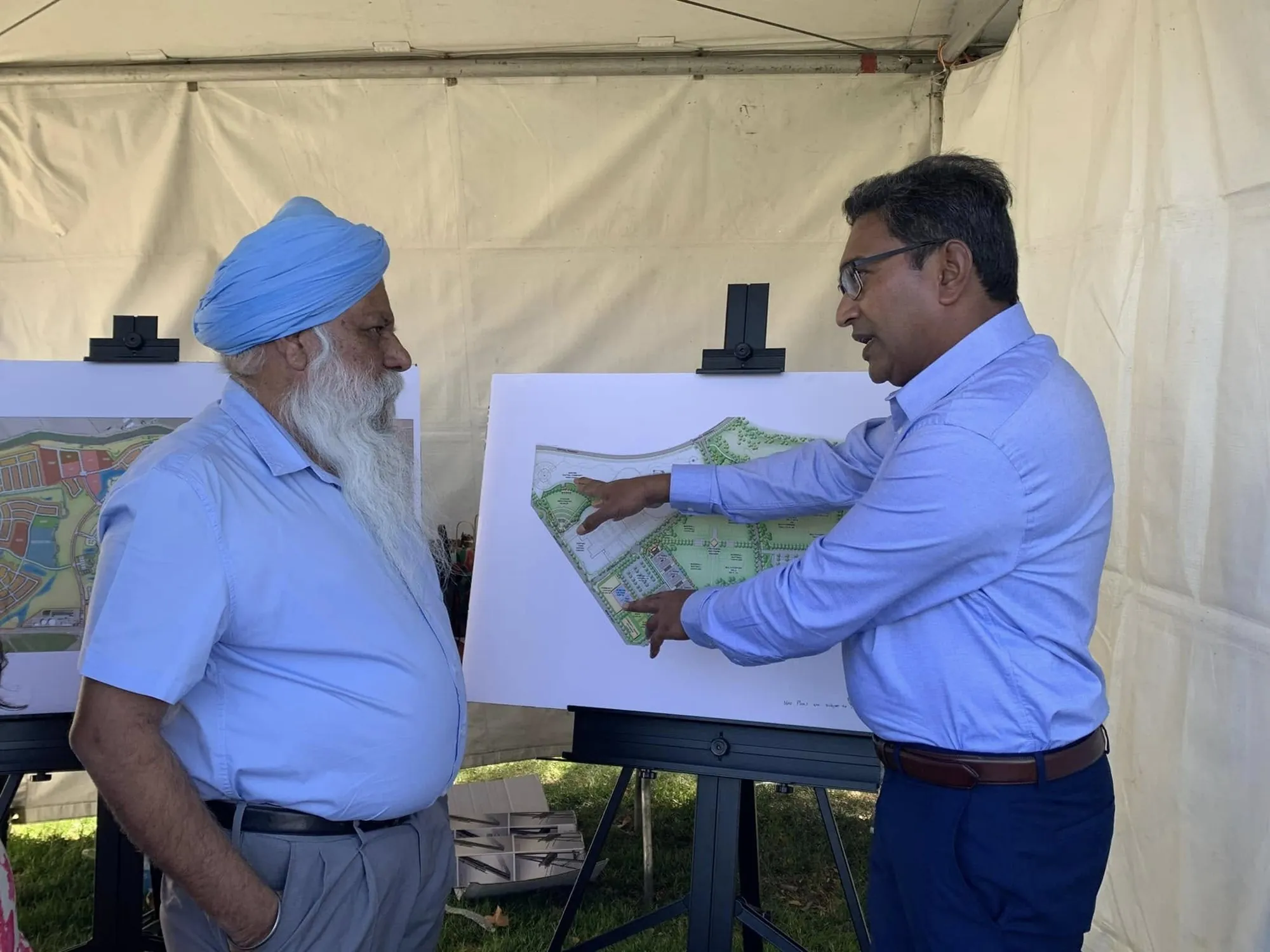 Suresh reviewing city plans with a resident